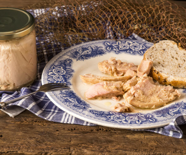 Albacore canned in glass with bread and tuna and plate beside