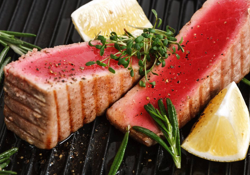 Grilled tuna with spice and lemon placed on a skillet
