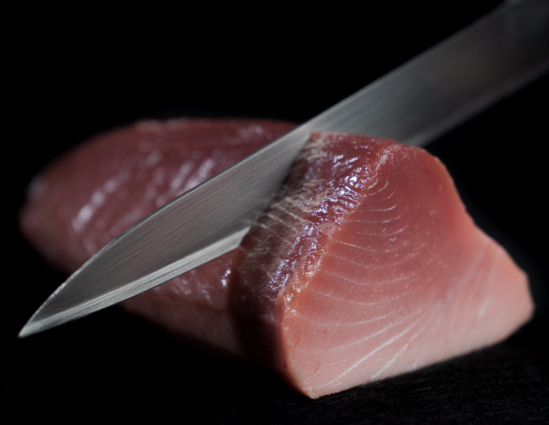 Knife slicing fresh Tuna