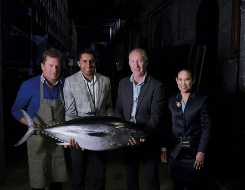 Group of people holding a big tuna fish