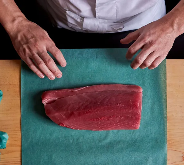 a man wrapping tuna fillet