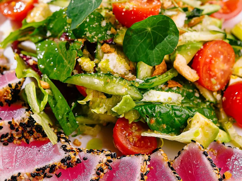 Appetizing seared tuna salad with fresh greens and tomatoes, presented elegantly