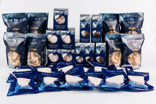 Assorted Lukina Seafoods Dinko Tuna products displayed in a grouped arrangement, featuring packaged tuna portions, boxed tuna cuts, and frozen seafood items in blue branded packaging against a white background.